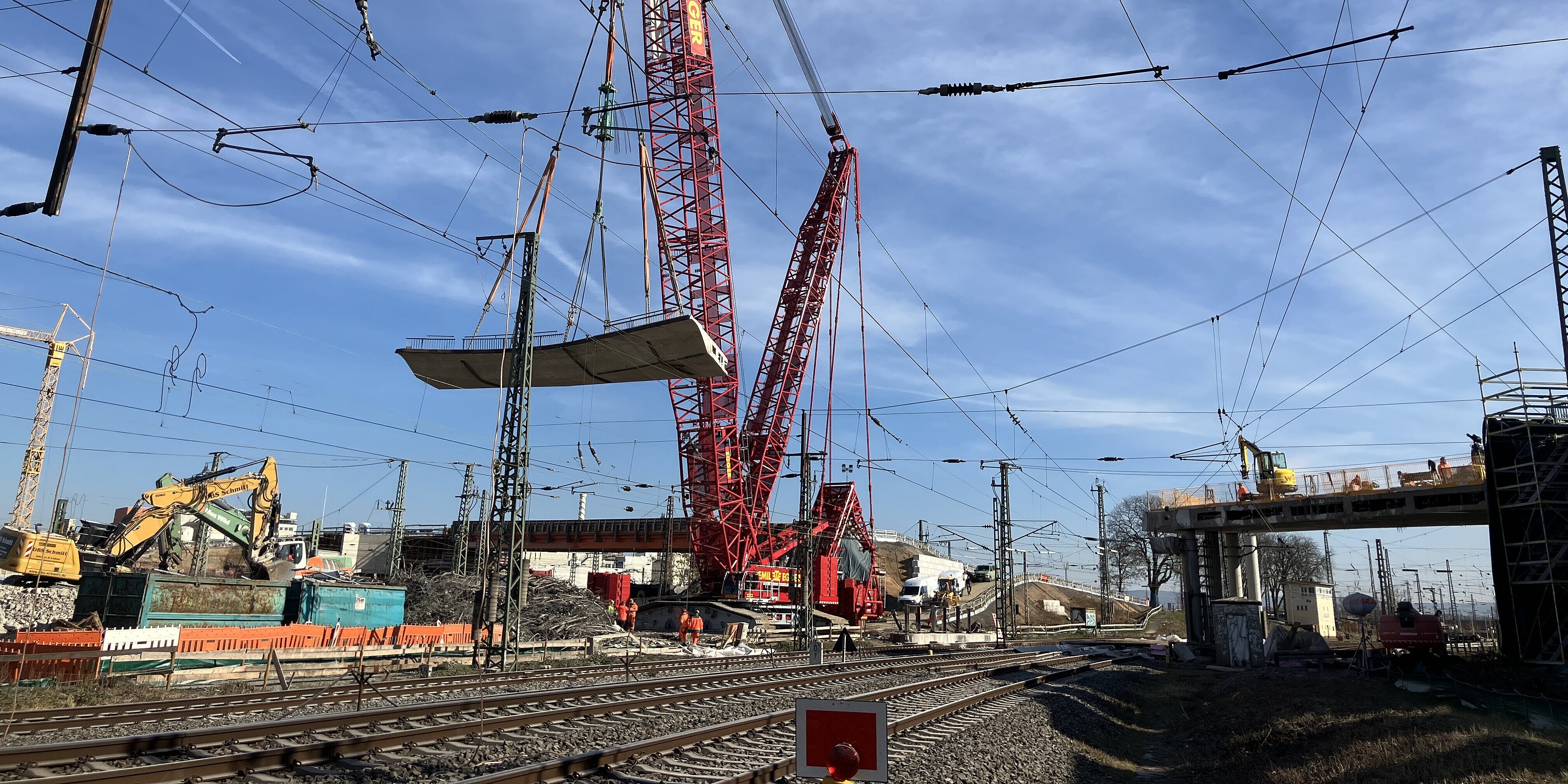 Ein Schwerlast-Raupenkran hebt ein massives Brückensegment der Hauptbahnhofbrücke in Hanau aus © KREBS+KIEFER