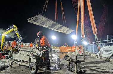 Fachkräfte schneiden die Brückenteile mit Spezialgeräten, während der nächste Abschnitt bereits für das Ausheben vorbereitet wird © KREBS+KIEFER